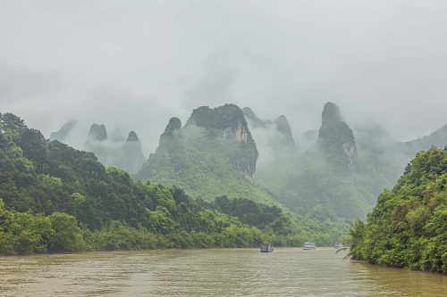 Vlies Fotótapéta - River bordering hills - 375x250 cm